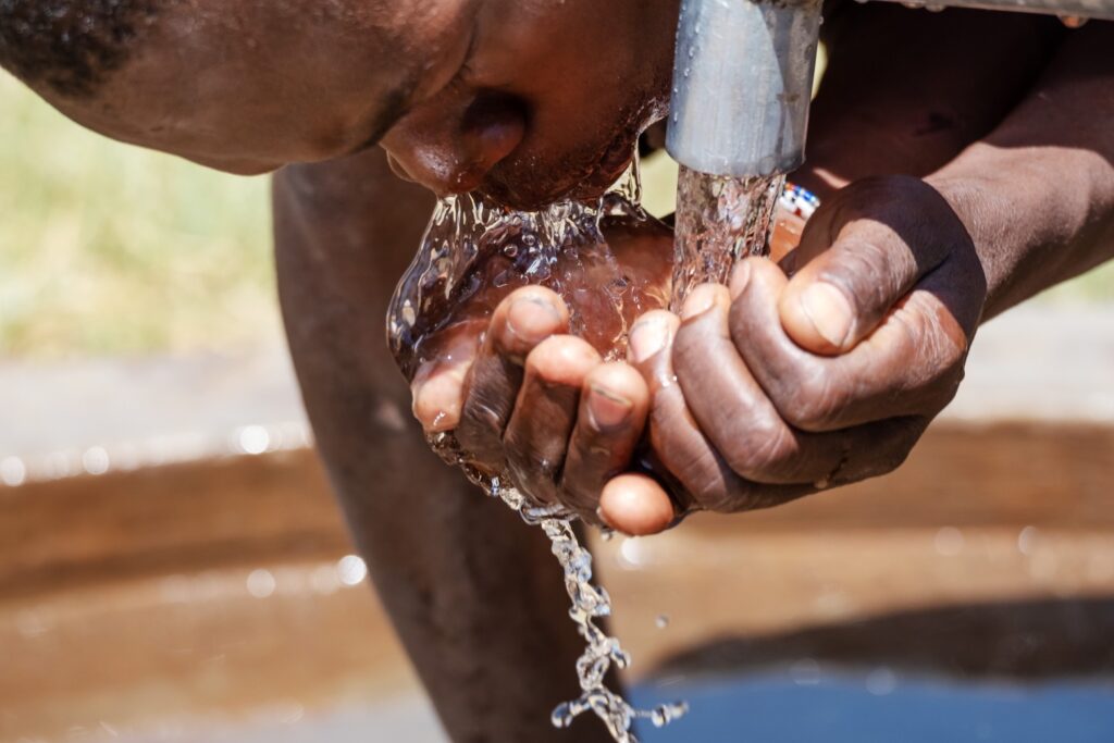 Mann trinkt Wasser - WASH4ALL in Uganda